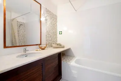a bathroom with a sink and a tub and a mirror at Casa dos Bisos in Albufeira
