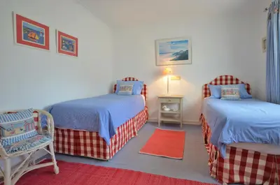 a bedroom with two beds and a red rug at Apartamento Mariana, Quinta do Lago