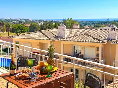 a table with a plate of food on a balcony at Casa Antonius, Sun & Pool Balaia Home by BeCherish in Atalaia
