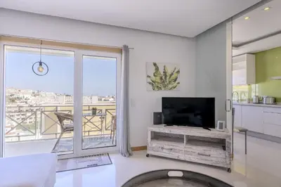 a living room with a tv and a large window at #340 Old Town Garden Hill Z by Home Holidays in Albufeira
