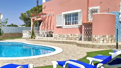 a resort with a swimming pool and chairs and a building at Vila Paraiso da Maria 5 quartos duas salas, jardim, piscina, varanda com churrasqueira e WIFI in Olhos de Água