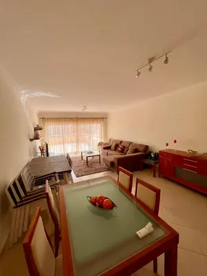 a living room with a table and a couch at Vilamoura apartment in Quarteira