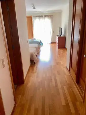 a bedroom with two beds and a wooden floor at Vilamoura apartment in Quarteira
