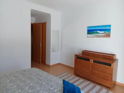 a bedroom with a bed and a wooden dresser at EncostaOasis Townhouse in Estibeira