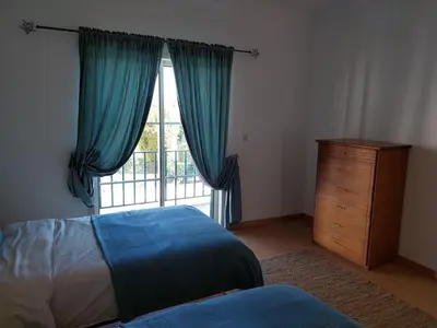 a bedroom with a bed and a large window at EncostaOasis Townhouse in Estibeira