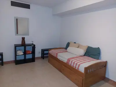 a bedroom with a wooden bed with a striped blanket at EncostaOasis Townhouse in Estibeira