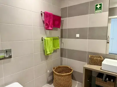 a bathroom with a sink and towels on the wall at Gabbiana apartment Albufeira terrace BBQ and pool in Albufeira
