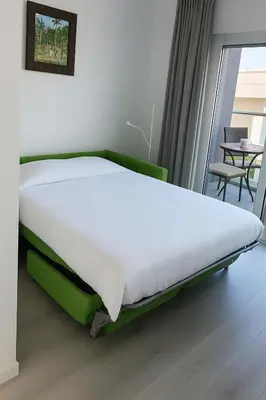 a large bed in a room with a table at Gabbiana apartment Albufeira terrace BBQ and pool in Albufeira