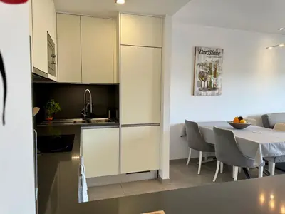 a kitchen and dining room with white cabinets and a table at Gabbiana apartment Albufeira terrace BBQ and pool in Albufeira