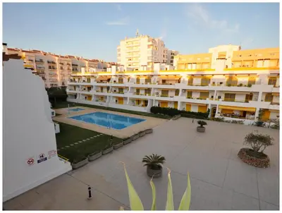 a sunset in the desert with a building and a street light at Apartamentos Capitolina in Quarteira