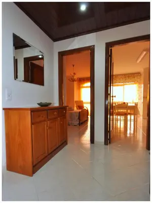 a living room with wood ceilings and a hallway at Apartamentos Capitolina in Quarteira