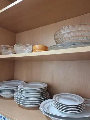 a stack of plates and bowls on a shelf at Happy House - Central Apartment in Faro