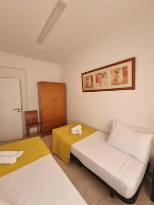 a bedroom with two beds and a cabinet in it at Happy House - Central Apartment in Faro