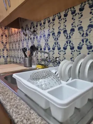 a kitchen counter with a white dishrack in a sink at Happy House - Central Apartment in Faro