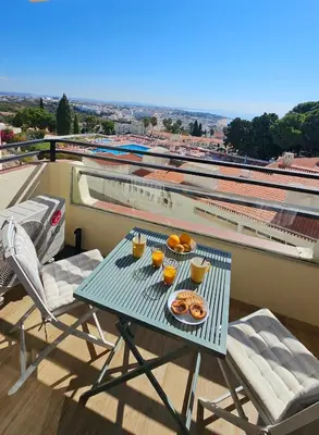 a table with food and orange juice on a balcony at Sea view studio, terrace & pools - Albufeira in Albufeira