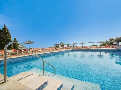 a large swimming pool with chairs and umbrellas at Sea view studio, terrace & pools - Albufeira in Albufeira