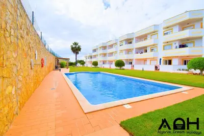 a swimming pool in front of a building at Sunny Terrace facing the pool and barbecue by Algarve Dream Holidays in Guia