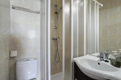 a bathroom with a white sink and a shower at Cozy 2BR Apartment in Albufeira with Balcony, by Hopstays in Albufeira