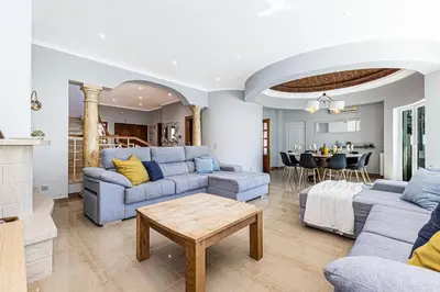 a living room with blue couches and a table at Quiet Villa Near The Beach, Opcional Heated Pool in Albufeira