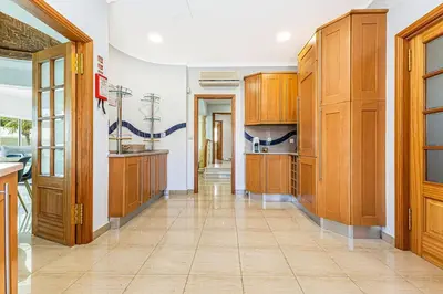 a large kitchen with wooden cabinets and a tile floor at Quiet Villa Near The Beach, Opcional Heated Pool in Albufeira