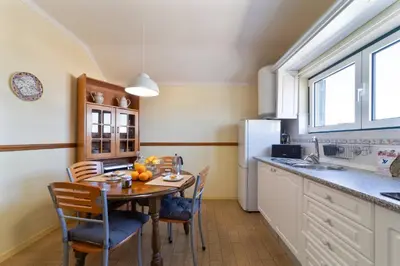 a kitchen with a table and chairs and a refrigerator at Vivenda Lemos A in Albufeira