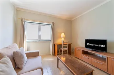 a living room with a couch and a tv at Vivenda Lemos B in Albufeira