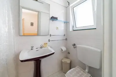 a bathroom with a sink and a toilet and a mirror at Vivenda Lemos C in Albufeira