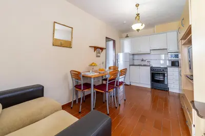 a kitchen and dining room with a table and chairs at Vivenda Lemos D in Albufeira