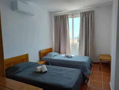 a hotel room with two beds and a window at Bay View Apartments in Albufeira