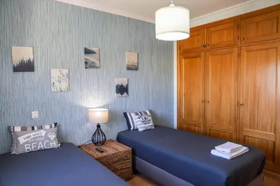 a bedroom with two twin beds and a lamp at Atlântida Golf Village by Garvetur in Quarteira