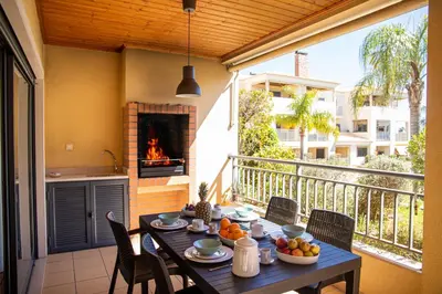 a table with fruit on a balcony with a fireplace at Terraços do Milénio II by Garvetur in Quarteira