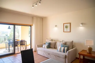 a living room with a couch and a table at Terraços do Milénio II by Garvetur in Quarteira