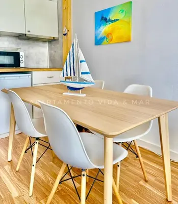 a wooden table with chairs and a toy sailboat on it at Apartamento Vida & Mar at Albufeira Beach in Albufeira