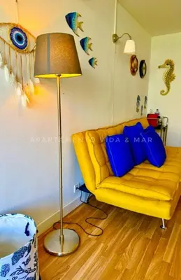 a living room with a yellow couch and a lamp at Apartamento Vida & Mar at Albufeira Beach in Albufeira