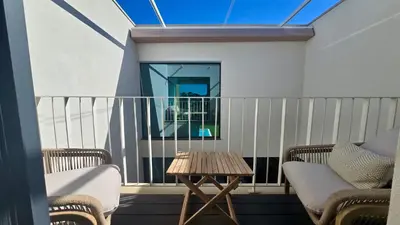 a balcony with two chairs and a wooden table at Casa Bougainvillea by CleverDetails, private pool 