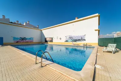 a large swimming pool in a building with a mural at Falésia Beach I by HelloVacations in Albufeira