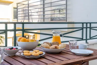 a table with bowls of food and a jug of orange juice at Falésia Beach I by HelloVacations in Albufeira
