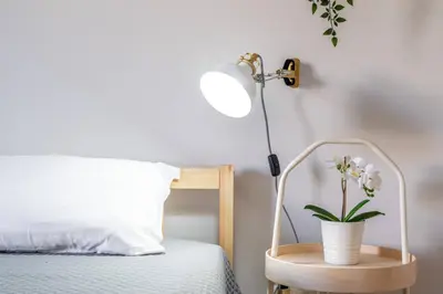 a lamp and a plant on a night stand next to a bed at Falésia Beach I by HelloVacations in Albufeira