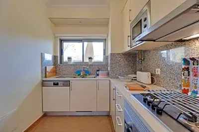 a kitchen with a sink and a stove top oven at Jardins da Marina by Albufeira Rental in Albufeira