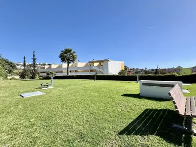 a large grassy yard with a building in the background at Jardins da Marina by Albufeira Rental in Albufeira