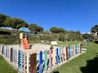 a colorful fence in a park with a playground at Jardins da Marina by Albufeira Rental in Albufeira