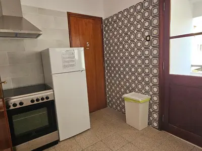 a kitchen with a refrigerator and a trash can at Blife Olindya private rooms in Faro