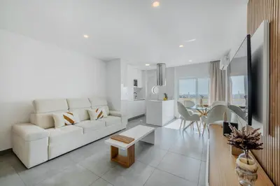 a white living room with a white couch and a table at Alexandra Paradise in Albufeira