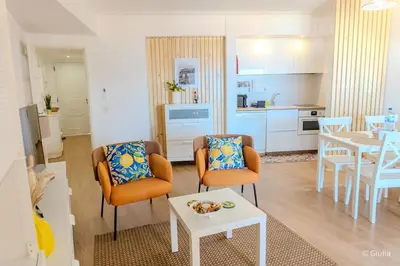 a living room with a table and chairs and a kitchen at Algarve Vilamoura Quarteira vue sur Ocean-Portugal in Quarteira
