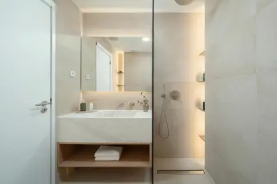 a white bathroom with a sink and a shower at Townhouse with Heated Pool in Downtown Faro in Faro