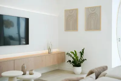 a living room with a couch and a tv on a wall at Townhouse with Heated Pool in Downtown Faro in Faro