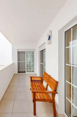 a wooden bench sitting in a room with windows at Albufeira Coast Apartment by Double Ninety Stays in Albufeira