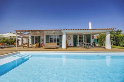 a villa with a swimming pool in front of a house at Villa Medicis by Villa Plus in Albufeira