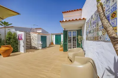 a house with a patio with chairs and a wall with tiles at Villa Medicis by Villa Plus in Albufeira