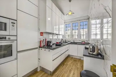 a kitchen with white cabinets and a large window at Villa Medicis by Villa Plus in Albufeira